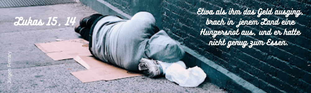 schlafender Mensch vor einer blauen Mauer auf der Straße 