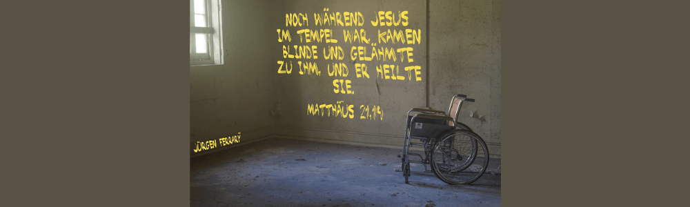 Ein Rollstuhl steht in einem Zimmer mit kahlen Wänden