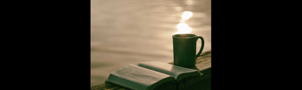 In der Bibel lesen mit einer Tasse Kaffee am Wasser